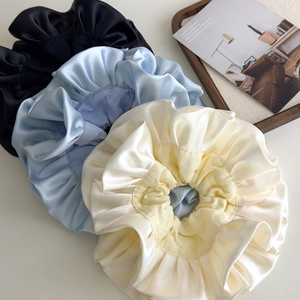 Three oversized double-layered satin scrunchies in black, light blue, and creamy white colors