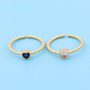 Close-up of gold beaded open rings with blue and white heart-shaped zircon stones