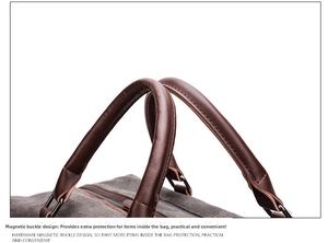 Close-up of durable leather handle and metal D-ring on a grey canvas travel bag