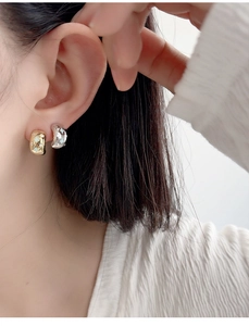 Macro detail of gold and silver sterling silver star earrings with zircons on model