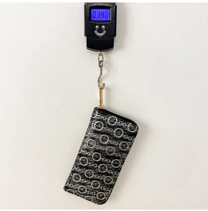 Detailed view of the large capacity PU long wallet being weighed on a scale showing 0.140kg