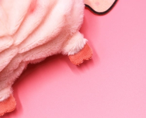 Close-up of soft pink plush fabric and detailed stitching on the cartoon coin purse