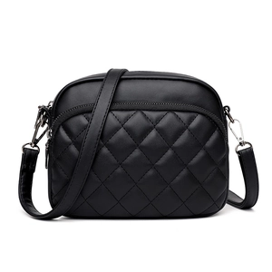 Fashionable black quilted crossbody bag with adjustable strap and zipper on white background