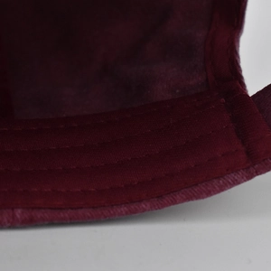 Macro shot of burgundy baseball cap interior showing fine stitching on the sweatband