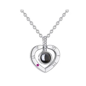 Detail of silver heart projection necklace with Roman numerals and pink gemstone