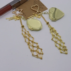 Detail of gold metal mesh keychain pendants with heart hooks and hollow tassel charms