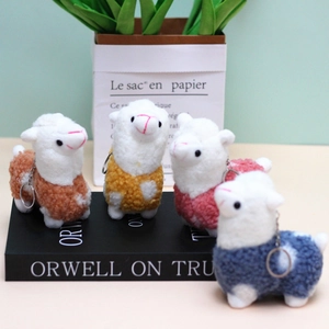 Detail view of four mini plush alpaca keychains in brown, yellow, pink, and blue colors
