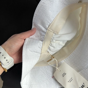 Detail of white sun hat showing sweatband and adjustable drawstring inside the brim