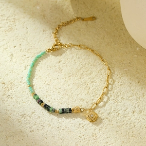 Detail of beaded bracelet with golden sunburst flower pendant and white cubic zirconia