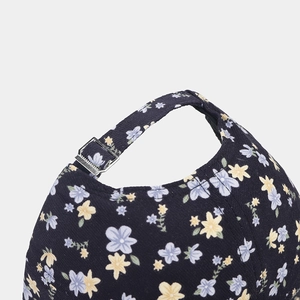 Detailed close-up of navy floral baseball cap with adjustable metal buckle and fabric texture