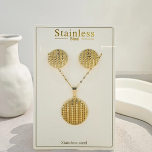 Detailed close-up of textured gold circular earrings and necklace set on display card