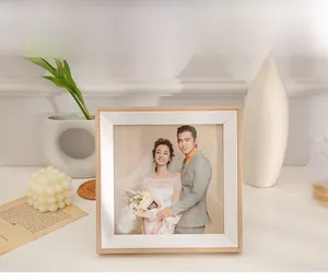 Close-up of a square wooden photo frame with white matting in a warm home setting