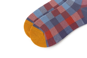 Close-up of vibrant plaid socks with red, blue, and purple patterns and yellow accents
