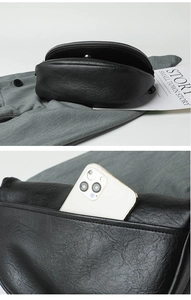 Detail view of black pebble leather bag with large main compartment and back phone pocket