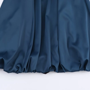 Fashionable dark blue satin midi dress featuring a stylish balloon hem and draped texture