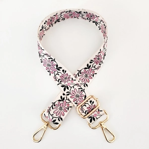 Detail of adjustable floral strap with pink patterns and gold metal lobster clasps