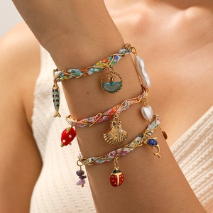 Bracelet bohème en tissu floral et chaîne dorée avec breloques coccinelle en émail