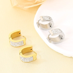 Detail view of U-shaped gold and silver stainless steel earrings with pavé-set crystals