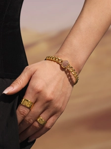 Detail of gold Cuban chain bracelet with pink zircon inlay and matching rings on model