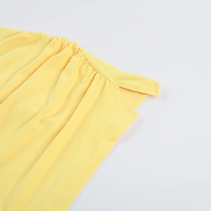 Detailed close-up of yellow bodycon dress showing side ruching and slit design details