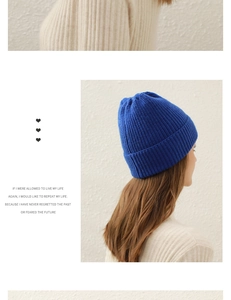 Blue knitted beanie shown on model against a minimalist background for winter style