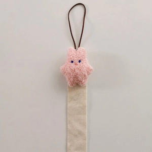 Close-up of a pink plush rabbit attached to a beige canvas strap for hair accessory storage