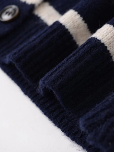 Detail of navy and cream striped knit cardigan showing ribbed cuffs and brown button