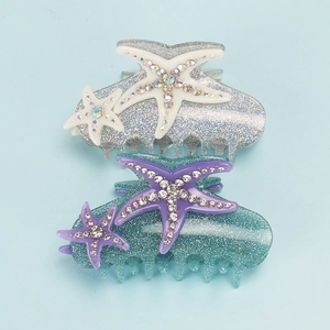 Close-up of starfish hair claws with sparkling glitter finish and colorful rhinestones