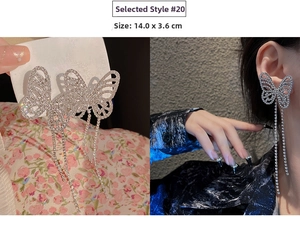 Detail of silver butterfly tassel earrings featuring rhinestone chains and hollow wings
