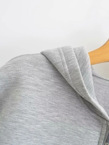 Close-up of the neckline and hood texture on a light gray cotton hoodie jacket