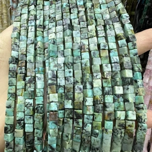 Gros plan de perles cubes en pierre naturelle verte avec motifs minéraux pour bijoux DIY