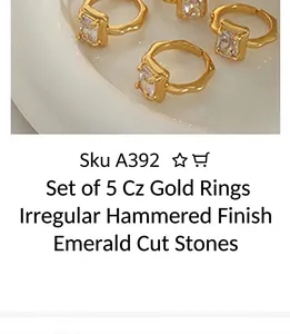 Macro shot of gold-plated lava texture rings with square zircon stones on a white tray
