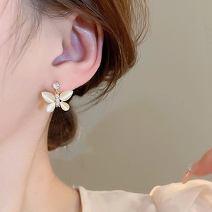 Elegant butterfly stud earrings with cat eye stones and zircons shown on the ear