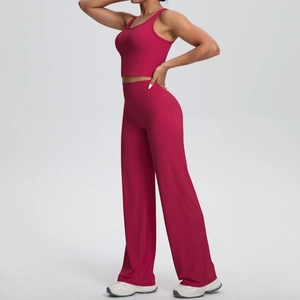 Dettaglio del set yoga rosso intenso con pantaloni a gamba larga a vita alta e crop top