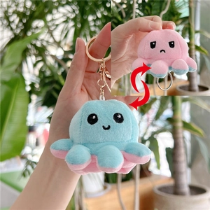 Detail of reversible octopus plush keychain showing blue happy and pink sad expressions