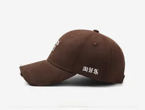 Detailed side view of dark brown baseball cap with embroidered characters and distressed brim