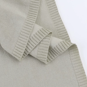 Detailopname van saliegroene gebreide stof met ribbeltextuur en afwerking van de zoom