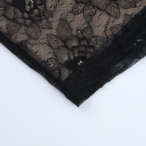 Gros plan sur la dentelle noire délicate avec doublure chair montrant les motifs floraux