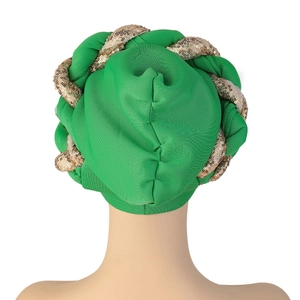 Detail view of the green turban showing knit texture and gold sequins on the braided band