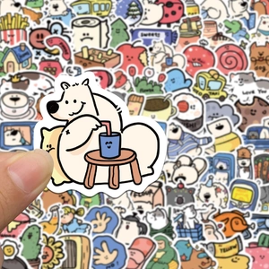 Nahaufnahme einer Hand, die einen wasserfesten Eisbären-Aufkleber über bunte Sticker hält