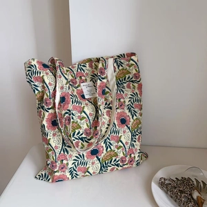 Detailed macro view of vintage floral print cotton tote bag with stitched square label