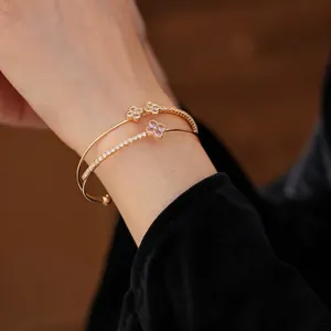 Double-layered gold open bangle featuring zircon petals and a purple four-leaf clover
