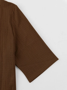 Close-up of men's short sleeve cuff showing the brown seersucker textured fabric