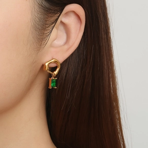 Boucles d'oreilles chic plaqué or 18K avec pierre verte portées de profil sur modèle