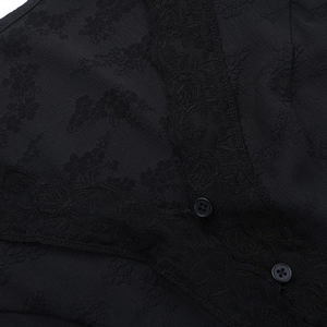 Détail de la bordure en dentelle florale noire et texture jacquard sur le gilet chic