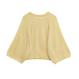 Texture de maille détaillée du pull court jaune clair avec poignets côtelés et manches larges