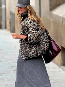 Detail of a leopard print puffer jacket with a high collar and reversible zip closure