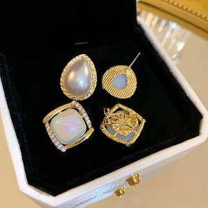 Detailed macro view showing teardrop and square resin earrings with faux opal stones