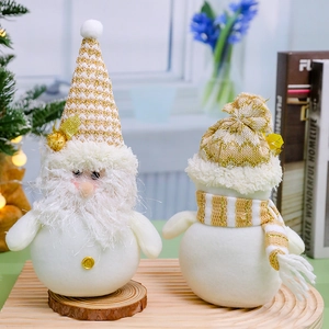 Christmas plush gnome and snowman figurines with gold accents on rustic wood base