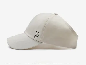 Side view of cream ponytail baseball cap featuring thick embroidered P letter logo
